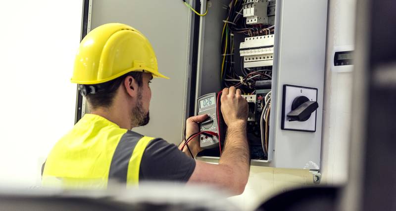 commercial electrician fixing a control panel